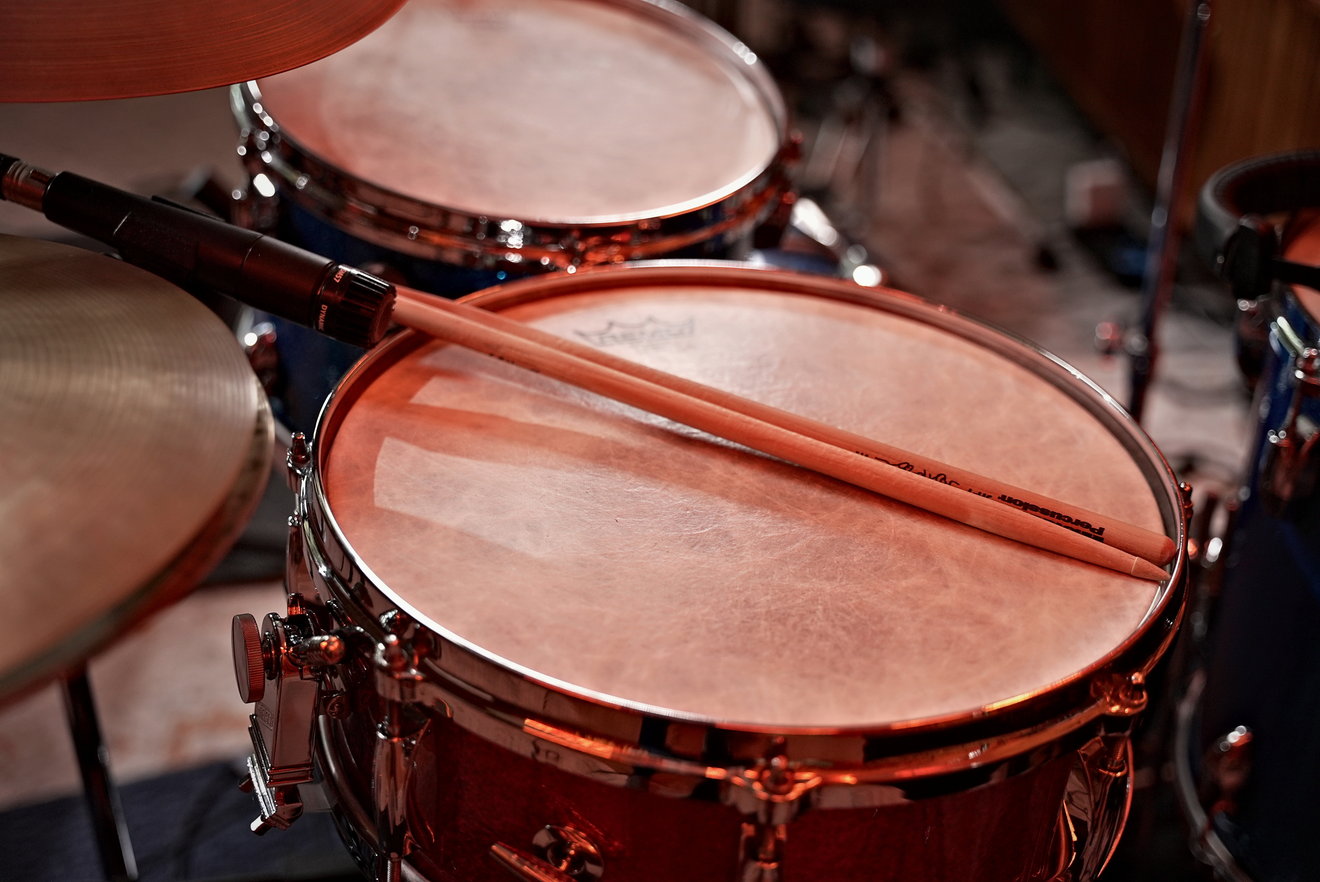 Drumsticks resting on a coated snare head